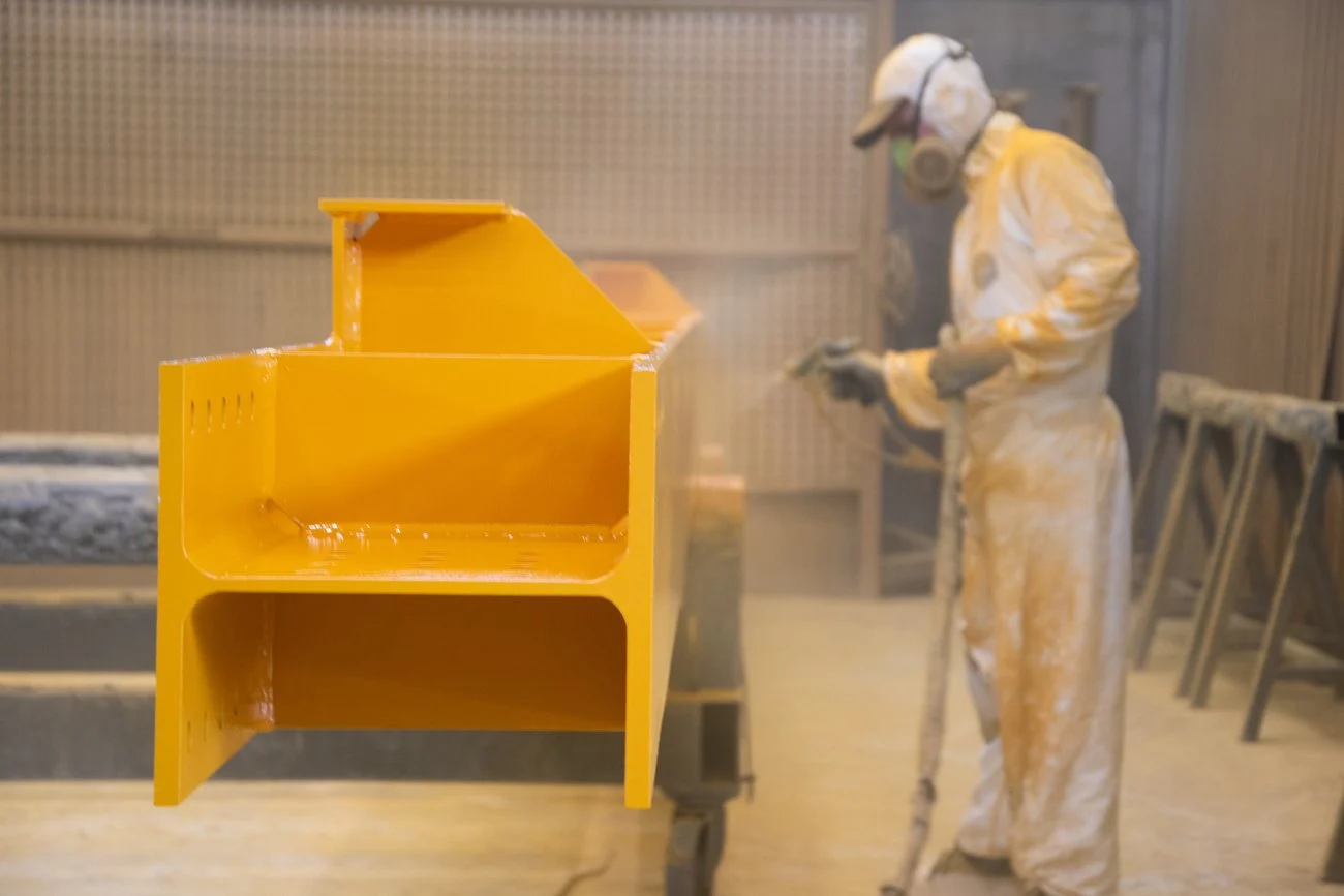 Verniciatura di un manufatto giallo in cabina